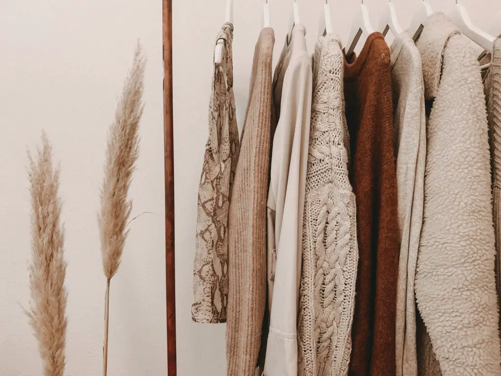 winter capsule wardrobe sweaters hanging on a rack