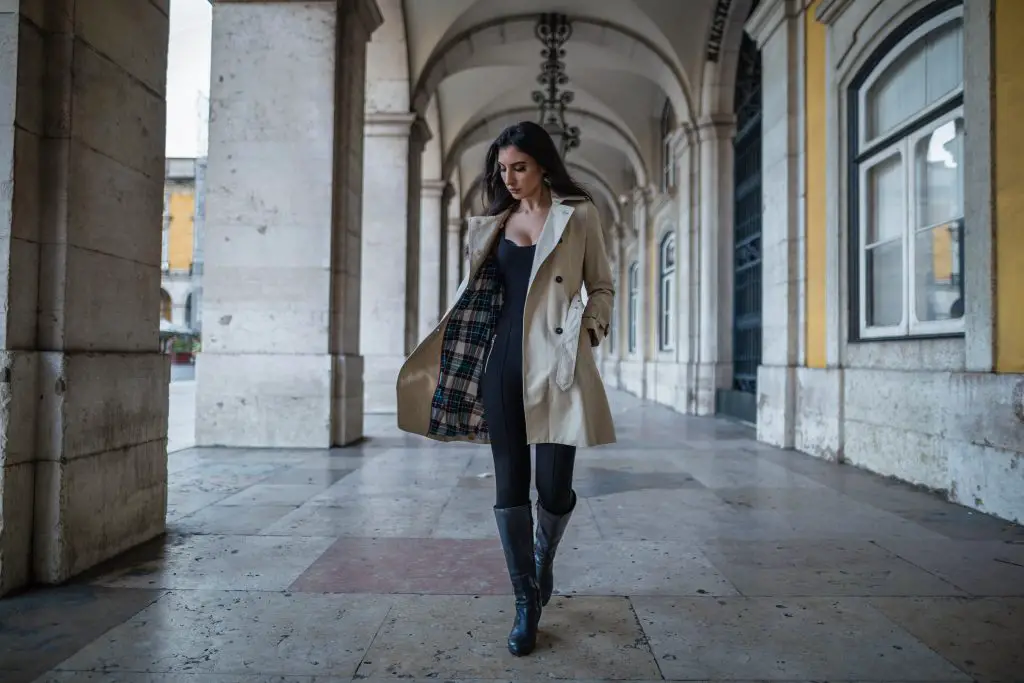 woman in trench coats walking in a cathedral