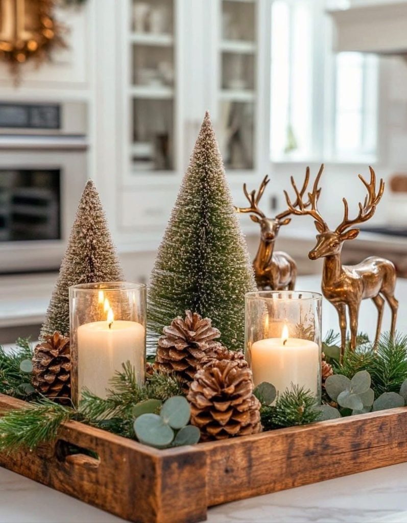 Christmas table centerpieces on a wooden tray with mini Christmas trees, pine cones, and deer decorations.